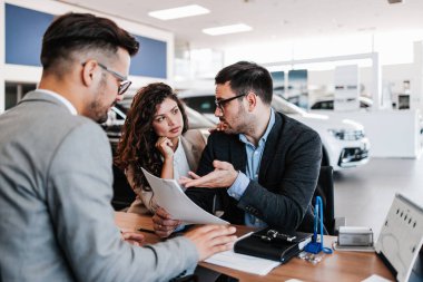 Karısı ile endişeli orta yaş adam araba salonu veya showroom araba satın alma. Kadın hala bir araba satın almak ister iken o sevk edilir.