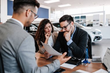 Karısı ile endişeli orta yaş adam araba salonu veya showroom araba satın alma. Kadın hala bir araba satın almak ister iken o sevk edilir.