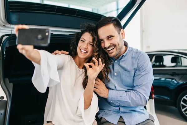中年夫妇在展示厅选购新车时快乐无比 — 图库照片