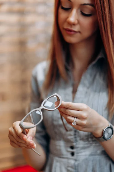 Beautiful Fashionable Redhead Woman Choosing Eyeglasses Frame Modern Optical Store — Foto Stock