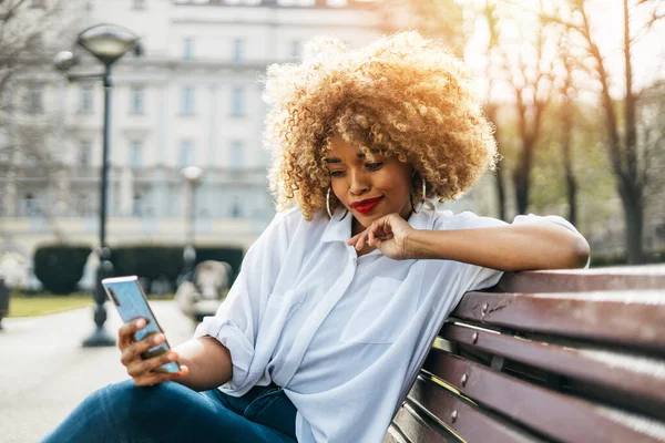 Güzel Siyah Kadın Sokak Bankında Oturuyor Online Iletişim Için Akıllı — Stok fotoğraf