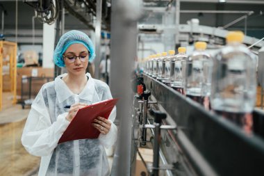 Tıbbi malzeme araştırma ve üretim fabrikasında çalışan ve sevkiyattan önce damıtılmış su kutularını kontrol eden koruyucu işçi. Denetim kalite denetimi. 