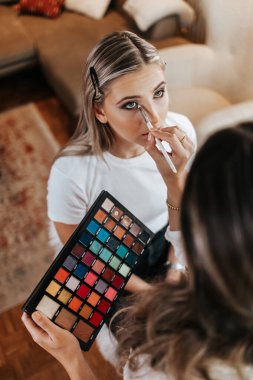 Makyaj süreci. Makyaj için makyaj yapan profesyonel bir sanatçı. Güzellik salonundaki güzel sarışın kadının portresini yakından çek.. 