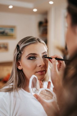 Makyaj süreci. Makyaj için makyaj yapan profesyonel bir sanatçı. Güzellik salonundaki güzel sarışın kadının portresini yakından çek.. 