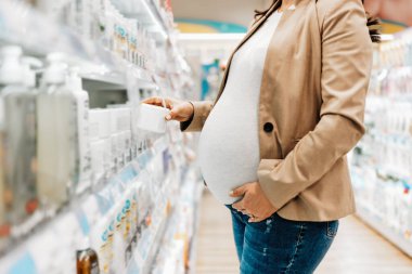 Güzel orta yaşlı anne bebek kozmetik ürünleri almaktan zevk alıyor. Ebeveynlik ve çocuk beklentisi. Yakın çekim..