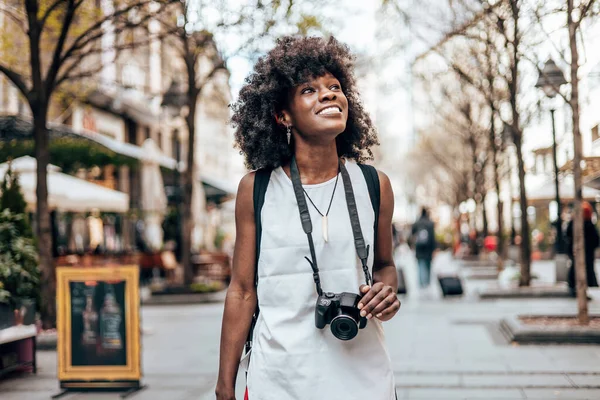 年轻的黑人女性游客喜欢在美丽的欧洲城市的街道上漫步 她很高兴 并使用她的摄影相机拍摄了精彩的建筑照片 阳光灿烂的日子 — 图库照片