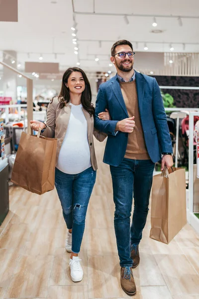 満足し幸せなカップルは赤ちゃんの店でショッピングバッグ 親と子供の期待の概念 — ストック写真