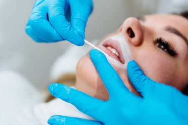 Professional permanent make up procedure. Tattoo lips makeup treatment in modern beauty salon.