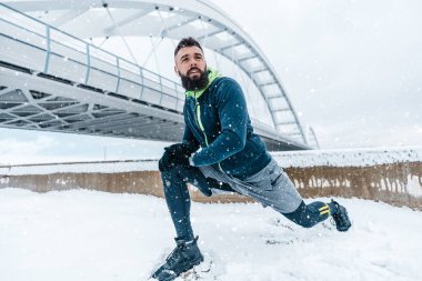 Çok soğuk ve karlı bir günde sakallı, koşan ve dışarıda egzersiz yapan yakışıklı orta yaşlı bir adam. Spor ve spor motivasyon teması.