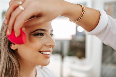 Makyaj süreci. Makyaj için makyaj yapan profesyonel bir sanatçı. Güzellik salonundaki güzel sarışın kadının portresini yakından çek.. 