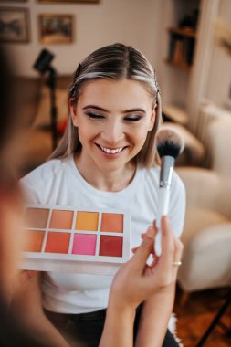 Makyaj süreci. Makyaj için makyaj yapan profesyonel bir sanatçı. Güzellik salonundaki güzel sarışın kadının portresini yakından çek.. 