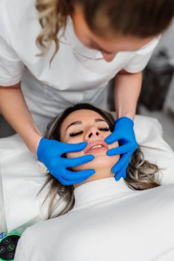 Professional permanent make up procedure. Tattoo lips makeup treatment in modern beauty salon.