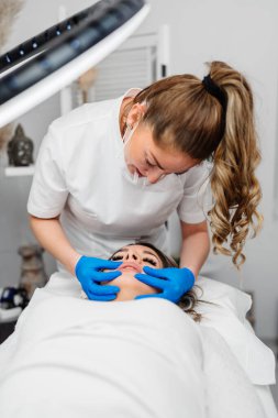 Professional permanent make up procedure. Tattoo lips makeup treatment in modern beauty salon.