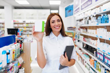 Güzel bir eczacı bir eczanede çalışıyor ve stok alımı yapıyor. Pozitif sağlık çalışanı portresi ya da iş yerinde çalışan bir kimyager..