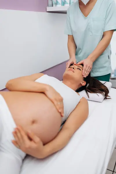 Beautiful Young Pregnant Woman Enjoying Relaxing Special Massage Treatment Maintaining 图库照片