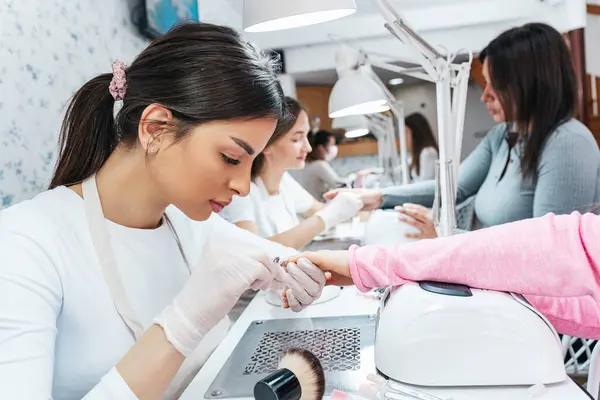 Professionele Manicure Werkzaam Een Moderne Schoonheidssalon Tevreden Vrouwelijke Klanten Ontvangen — Stockfoto