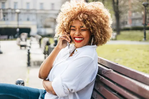 Beautiful Black Woman Sits Street Bench Uses Smarphone Online Communication Стоковое Фото