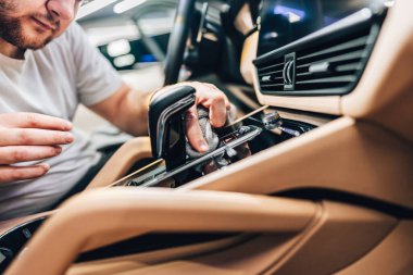 Mikrofiber bezle, araba temizleme ya da vale konseptiyle araba temizleyen bir adam. Seçici odak.