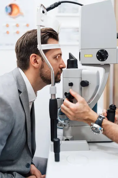 Привлекательный Врач Врач Офтальмолог Проверяет Зрение Красивого Мужчины Среднего Возраста Лицензионные Стоковые Изображения