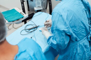 Yetenekli cerrah ve tıbbi ekibi yaşlı bir hastaya hassas bir göz ameliyatı yaparak en son tıbbi teknoloji ve ileri teknoloji ile görme yetisini geri kazandırıyor. Modern göz ameliyatı konsepti.