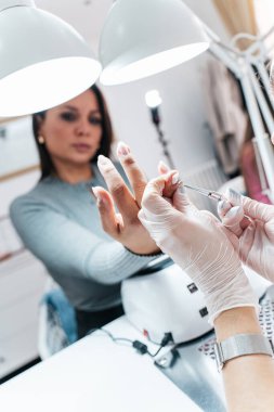Modern bir güzellik salonunda çalışan profesyonel bir manikürcü. Kaplıcada manikür tedavisi gören tatmin olmuş bir bayan müşteri..