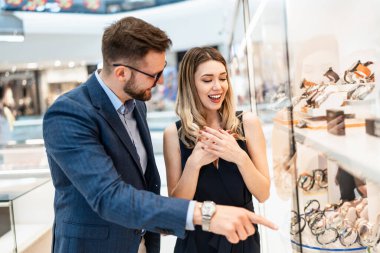 Modern kuyumcuda alışveriş yapan güzel bir çift. Erkekler moda ve zarafet konsepti.