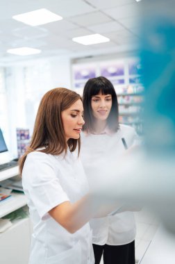 İki güzel eczacı bir eczanede birlikte çalışıp hisse senedi alıyorlar. Pozitif sağlık çalışanlarının portresi ya da iş yerindeki kimyagerlerin..