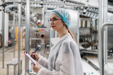 Tıbbi malzeme araştırma ve üretim fabrikasında çalışan ve sevkiyattan önce damıtılmış su kutularını kontrol eden koruyucu işçi. Denetim kalite denetimi. 