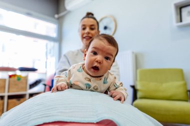 Sevimli kız, uzman bir çocuk spor salonunda veya oyun alanında uzman bir terapistle fizik tedavi seanslarından hoşlanıyor..