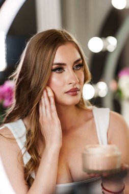 Makyaj stüdyosunda çalışan genç ve güzel bir bayan profesyonel makyöz. O, kendini toparlamaktan hoşlanır. Yüzüne makyaj yapan muhteşem bir manken..