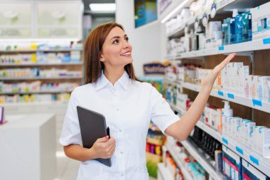 Güzel bir eczacı bir eczanede çalışıyor ve stok alımı yapıyor. Pozitif sağlık çalışanı portresi ya da iş yerinde çalışan bir kimyager..