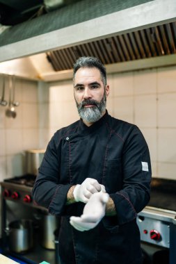 Yakışıklı sakallı profesyonel şef restoran mutfağında çalışıyor. O, balık ve deniz ürünleriyle sağlıklı lezzetli yemekler hazırlar..