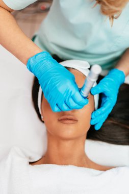 Professional cosmetologist making mesotherapy injection with dermapen on face for effective skin rejuvenation. Modern cosmetology spa treatment.