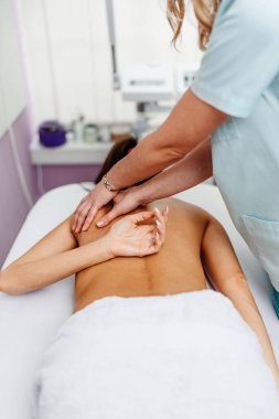 Güzel, genç, yetişkin bir esmer güzellik salonunda profesyonel masaj tedavisi görüyor..
