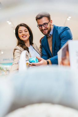 Çekici orta yaşlı çift beşikte salıncak almaktan zevk alıyor. Bebek dükkanında ya da dükkanda güzel bir çift. Çocuk beklenen kavram.
