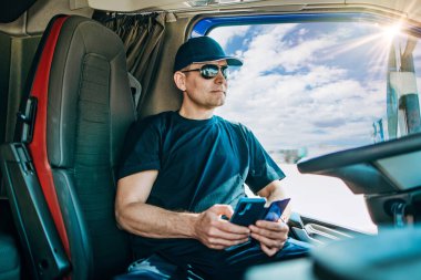 Tecrübeli kamyon şoförü kamyonetinde oturuyor ve yeni bir rota bekliyor.. 