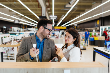 Güzel ve mutlu orta yaşlı bir çift modern ev aletleri mağazasından tüketici ürünleri alıyor. Sakal, saç kesme makinesi ve saç kurutma makinesini seçiyorlar. Halk ve tüketim kavramı.