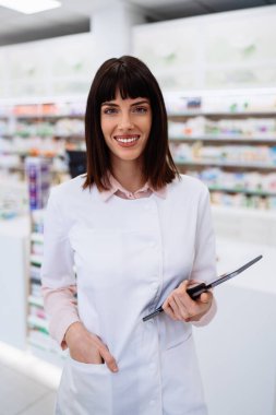 Güzel bir eczacı bir eczanede çalışıyor ve stok alımı yapıyor. Pozitif sağlık çalışanı portresi ya da iş yerinde çalışan bir kimyager..