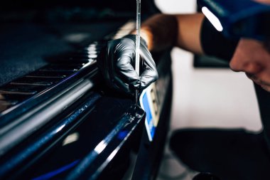 Profesyonel işçi, araba tamirhanesinde ve vale servisinde lüks araba tırmalamalarını tamir ediyor. Seçici odak.