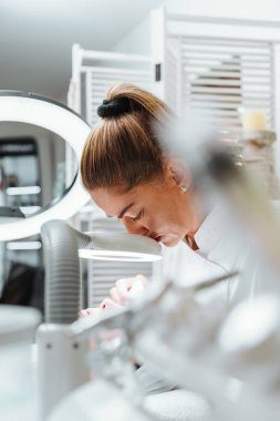 Modern donanımlı güzellik merkezinde profesyonel bir güzellik uzmanı genç bir kadının yüzündeki sivilceleri ve sivilceleri elle temizliyor. Güzelleştirme ve cilt sağlığı kavramı.