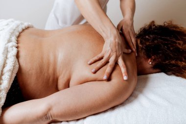 Obez orta yaşlı kadın, kilo azaltma ve kötü duruşu düzeltme amaçlı özel bir vücut masajı yaptırır. Modern kilo kaybı fizik tedavi ve güzellik spa konsepti.