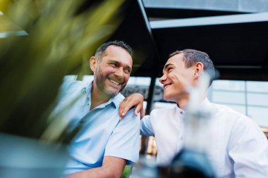 Yakışıklı ve mutlu baba ve genç oğlu bir restoranda oturup konuşuyorlar..