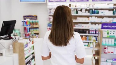 Güzel bir eczacı bir eczanede çalışıyor ve stok alımı yapıyor. Pozitif sağlık çalışanı portresi ya da iş yerinde çalışan bir kimyager..