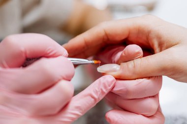 Modern bir güzellik salonunda çalışan profesyonel bir manikürcü. Kadın müşteri kaplıca merkezinde manikür tedavisi görüyor. Yakın çekim..