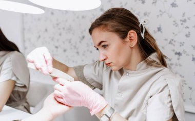 Modern bir güzellik salonunda çalışan profesyonel bir manikürcü. Kaplıcada manikür tedavisi gören tatmin olmuş bir bayan müşteri..