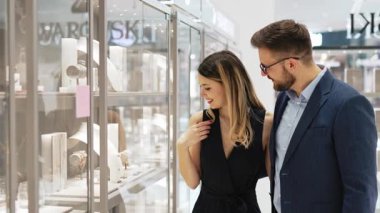 Modern kuyumcuda tatil alışverişinde eğlenen güzel bir çift. Moda tarzı ve tüketim konsepti.