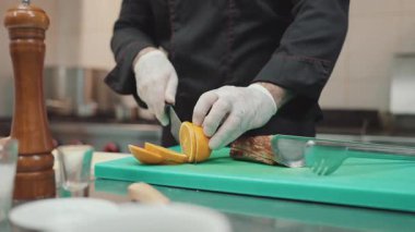 Yakışıklı sakallı profesyonel şef restoran mutfağında çalışıyor. O, balık ve deniz ürünleriyle sağlıklı lezzetli yemekler hazırlar..