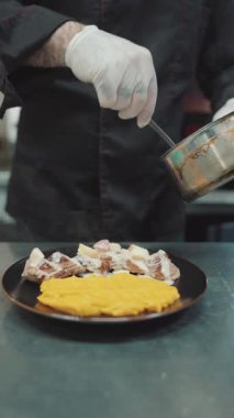 Yakışıklı sakallı profesyonel şef restoran mutfağında çalışıyor. O, balık ve deniz ürünleriyle sağlıklı lezzetli yemekler hazırlar..