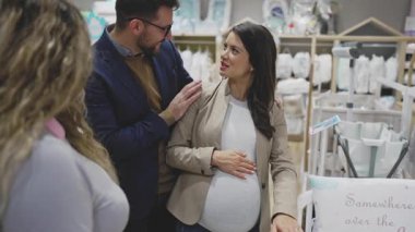 Çekici, orta yaşlı bir çift yeni bebekleri için elbise ve eşyalar almaktan zevk alıyor. Bebek dükkanında ya da dükkanda güzel bir çift. Bebek konsepti bekleniyor..