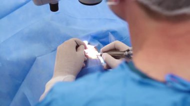 Yetenekli cerrah ve tıbbi ekibi yaşlı bir hastaya hassas bir göz ameliyatı yaparak en son tıbbi teknoloji ve ileri teknoloji ile görme yetisini geri kazandırıyor. Modern göz ameliyatı konsepti.